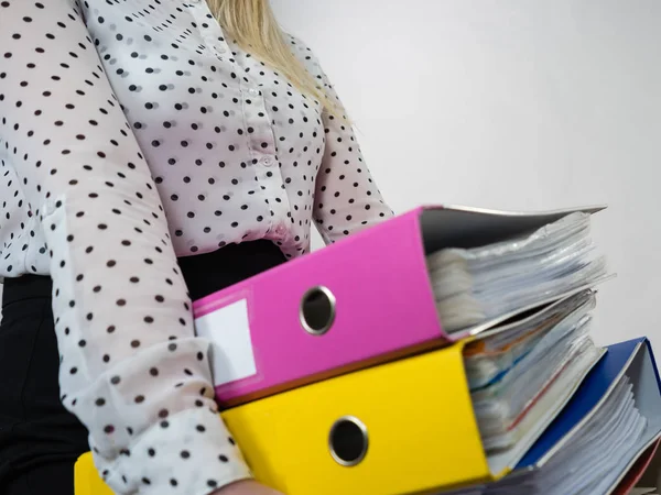 Donna che tiene pesanti raccoglitori colorati con documenti — Foto Stock