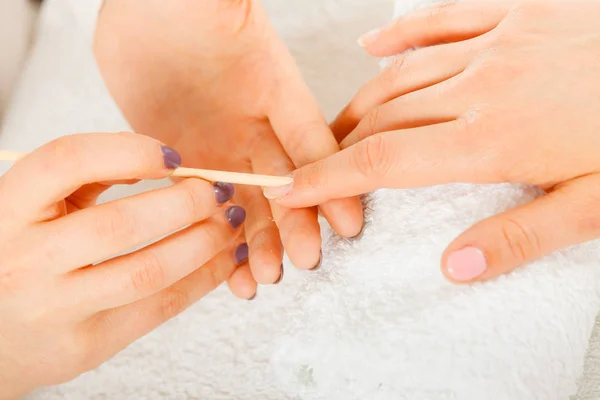 Esteticista preparando las uñas antes de la manicura, empujando hacia atrás las cutículas — Foto de Stock