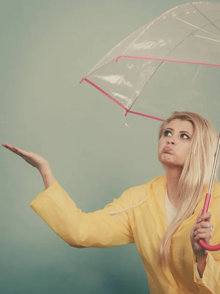 Mujer vistiendo impermeable sosteniendo paraguas comprobando el clima — Foto de Stock