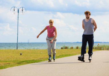 Gençler birlikte sahil parkta paten.