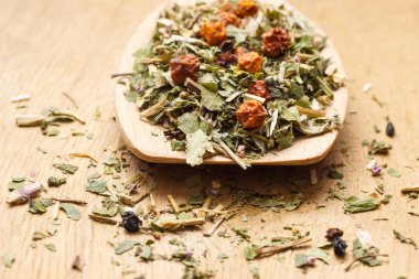 Kuru bitki yaprakları ve meyve üzerinde tahta kaşık yığını