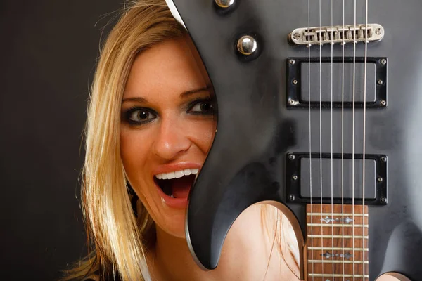 Donna bionda con chitarra elettrica, sfondo nero — Foto Stock