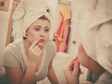 Bir kadın aynadaki yansımasına bakıyor.