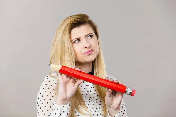 Woman confused thinking, big pencil in hand — Stock Photo, Image