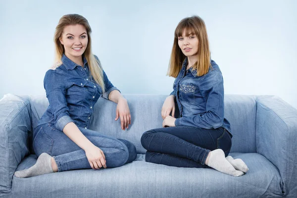 Two happy women friends wearing jeans outfit