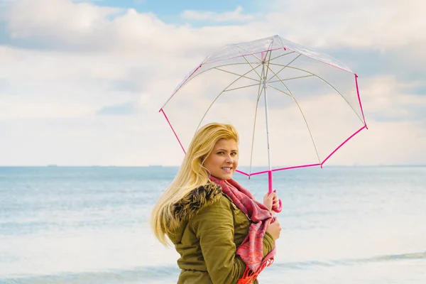 Femme debout avec parapluie transparent sur la plage — Photo