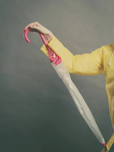 Mujer con impermeable sosteniendo paraguas cerrado — Foto de Stock