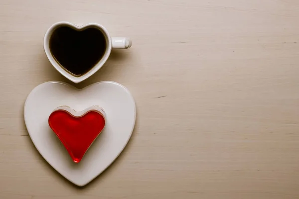 Copa de café en forma de corazón y pastel en la superficie de madera —  Fotos de Stock