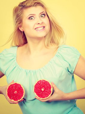 Kırmızı greyfurt meme üzerinde tutan kadın