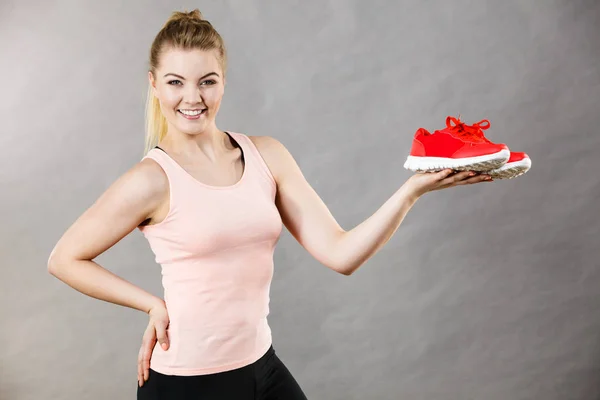 Glückliche Frau präsentiert Sportbekleidung Turnschuhe — Stockfoto