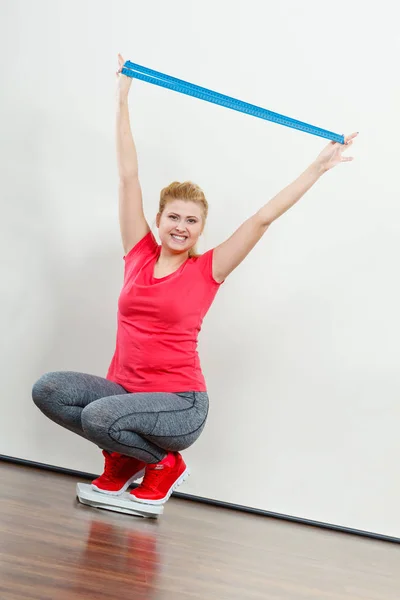 Woman wearing sportswear standing on weight machine — Stock Photo, Image