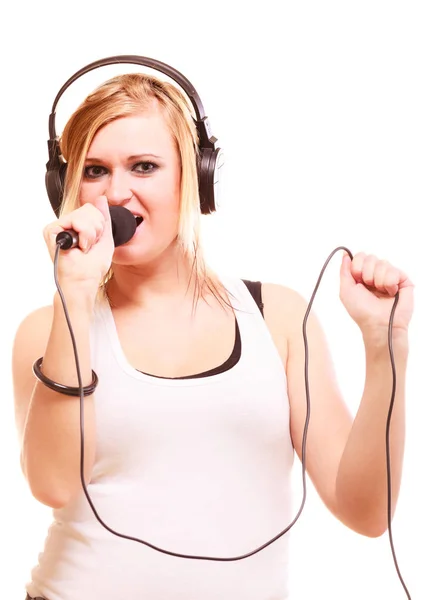 Kvinnan som sjunger till mikrofon bär hörlurar — Stockfoto