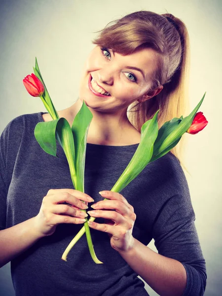 Glückliche blonde Frau mit Frühlingsblume. — Stockfoto