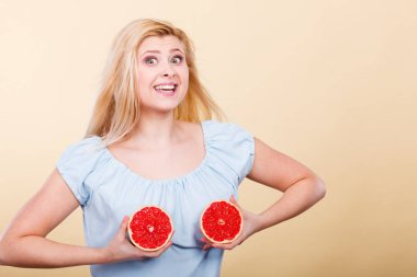 Kırmızı greyfurt meme üzerinde tutan kadın