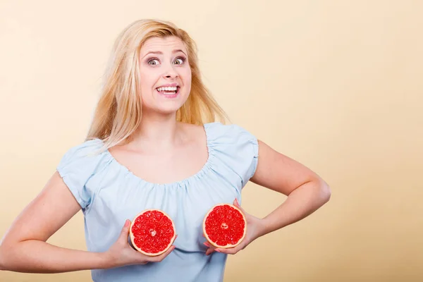 Vrouw met rode grapefruit op borst — Stockfoto