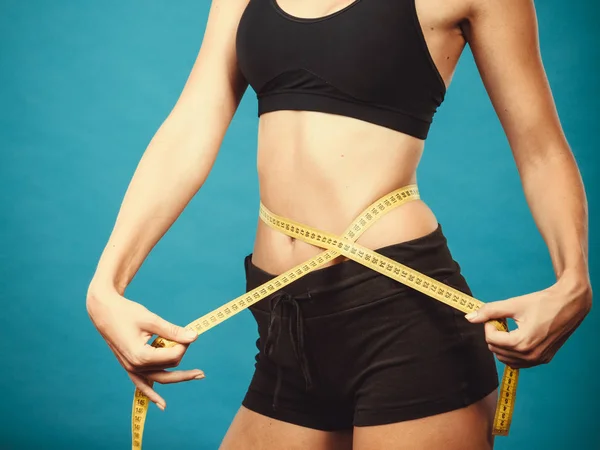 Fitness girl measuring her waistline — Stock Photo, Image