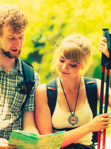 Excursionistas mochileros pareja lectura mapa en viaje . — Foto de Stock