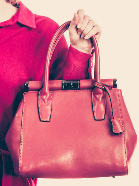 Female holding brown leather bag