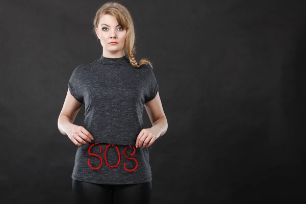 Woman holding red SOS sign, she need help — Stock Photo, Image