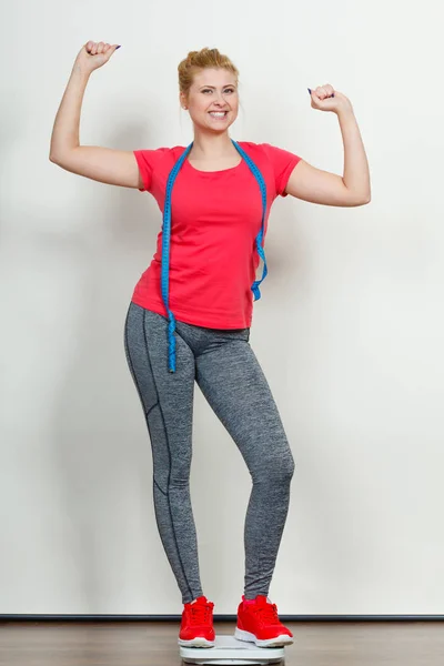 Vrouw het dragen van sportkleding staande op gewicht machine — Stockfoto