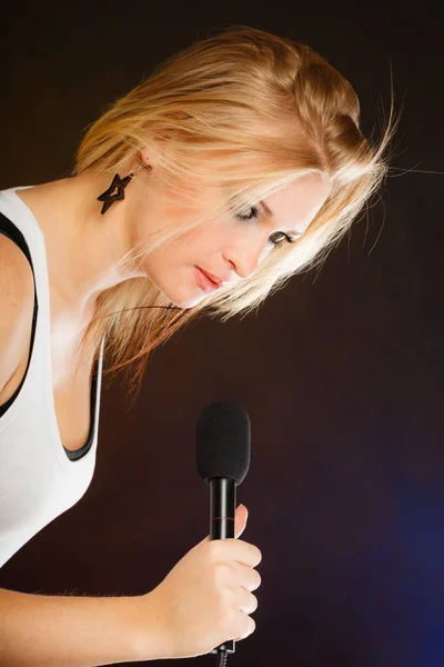 Ξανθιά γυναίκα, τραγουδώντας για το μικρόφωνο — Φωτογραφία Αρχείου
