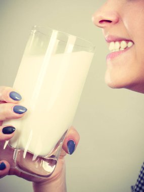 Kadın bardaktan süt içiyor.