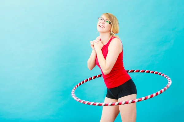 Подходящая женщина с обручем хула делает упражнения — стоковое фото