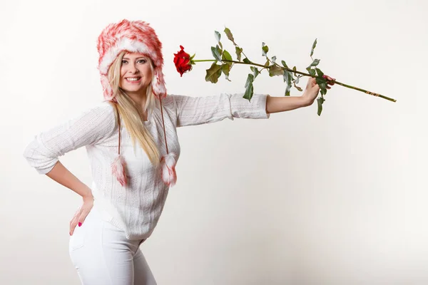 Mujer en invierno sombrero peludo sosteniendo rosa roja —  Fotos de Stock
