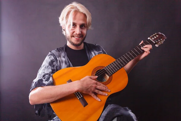 Biondo uomo suonare la chitarra acustica — Foto Stock