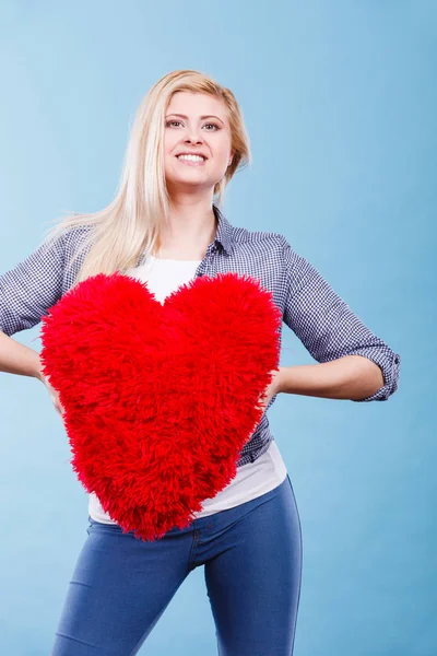 Mujer feliz sosteniendo almohada roja en forma de corazón — Foto de Stock