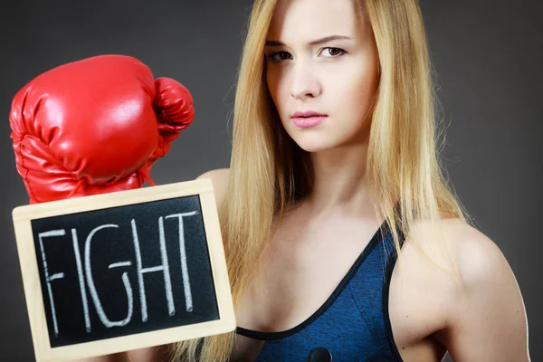 Mujer usando guante de boxeo sosteniendo signo de lucha — Foto de Stock