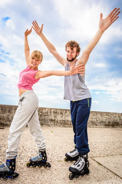 Dos personas en patines con brazos extendidos . — Foto de Stock