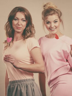 Karnaval aksesuarları tutan iki kadın