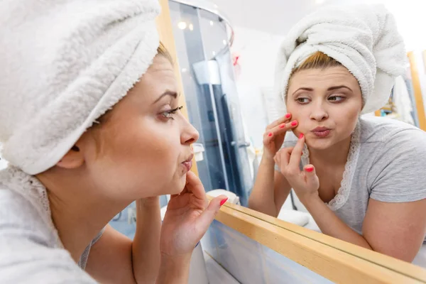 Vrouw op zoek bij de spiegel behandeling van acne — Stockfoto