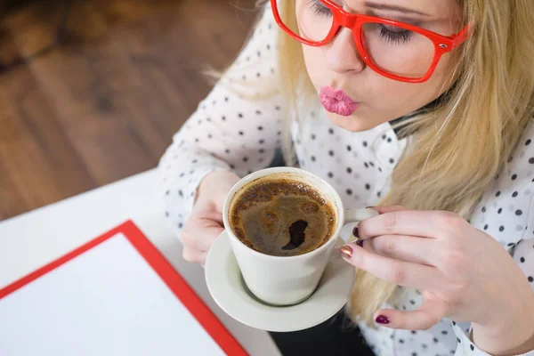 Gelukkige vrouw op kantoor warme koffie drinken — Stockfoto