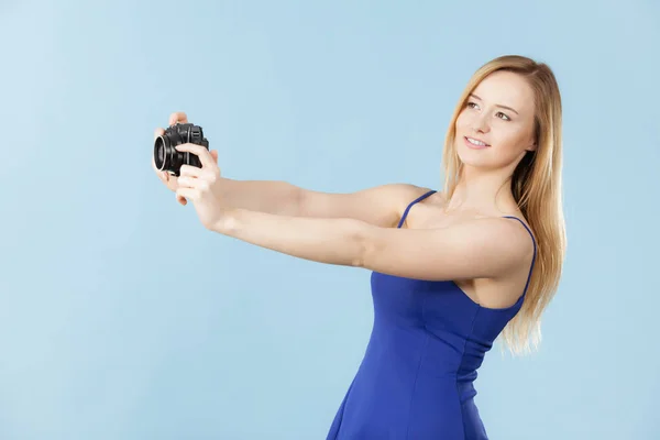 Blonde woman with camera on blue — Stock Photo, Image