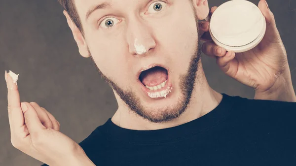 Mujer aplicando crema a su cara de hombre . —  Fotos de Stock