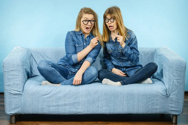Sahte gözlük sopa üzerinde tutan iki şok kadın — Stok fotoğraf