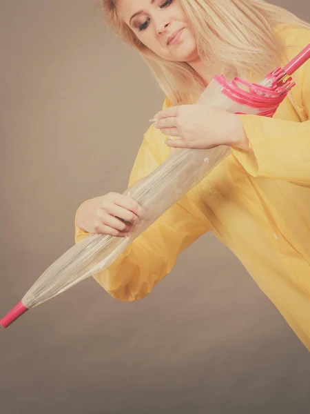 Woman wearing raincoat closing umbrella — Stock Photo, Image
