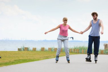 Genç bir çift paten yaparken elele