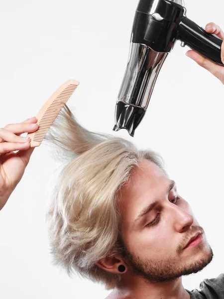 Joven hombre secando el cabello con secador de pelo — Foto de Stock