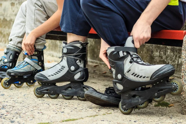 Gente amigos poniendo en patines al aire libre . — Foto de Stock