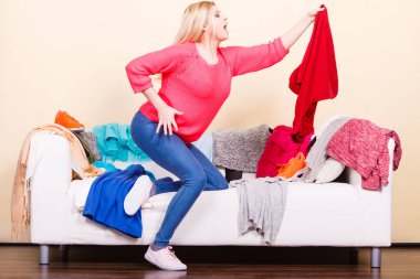 Kadın giysileri dağınık kanepede aracılığıyla arıyor