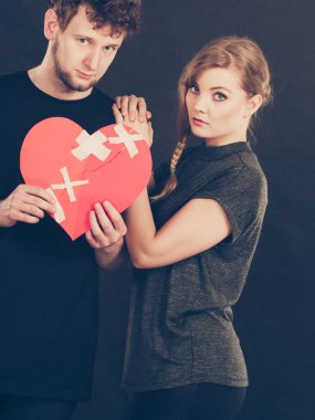 Üzgün iki kırık kalp tutar.