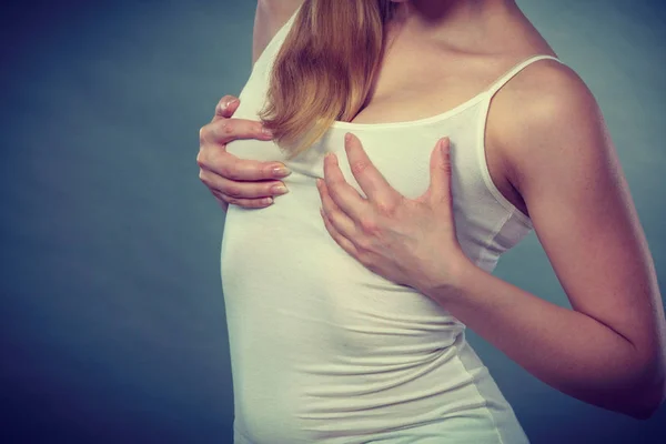 Kvinna som håller händerna på hennes bröst — Stockfoto
