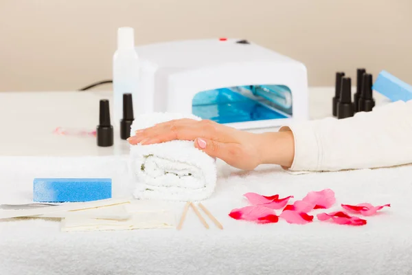 Mulher mão na toalha, ao lado do conjunto de manicure — Fotografia de Stock