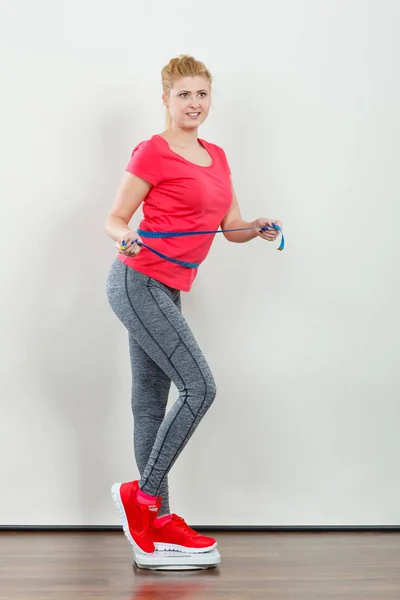 Woman wearing sportswear standing on weight machine — Stock Photo, Image