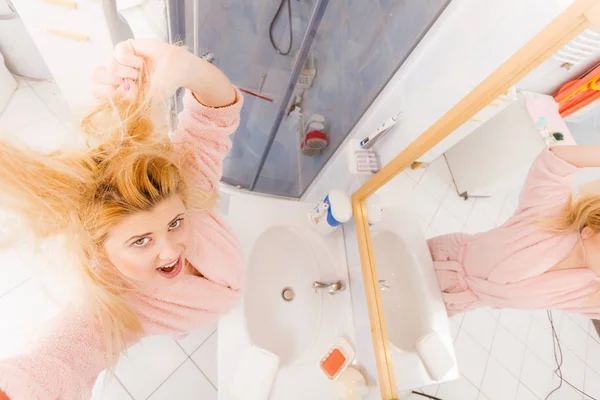 Mulher olhando para seu cabelo loiro muito emaranhado — Fotografia de Stock