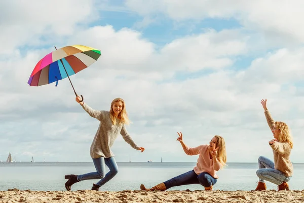 Mujeres sosteniendo paraguas divirtiéndose con amigos — Foto de Stock