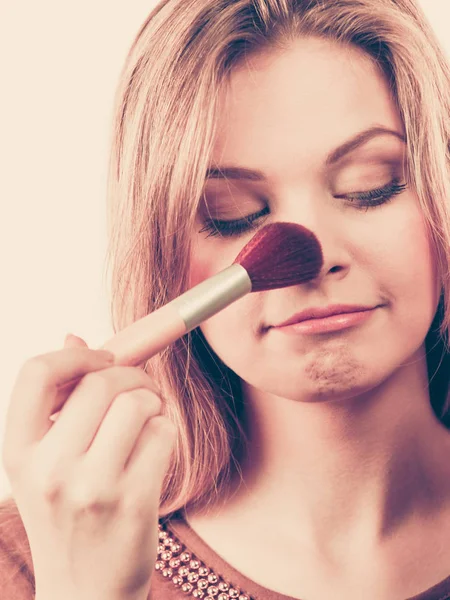 Usmívající se žena hospodářství make-upu štětec — Stock fotografie